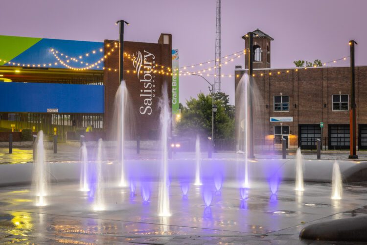 Unity Square Splash Pad with purple and yellow lights at night
