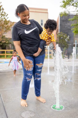 Mother and daughter playing in jet of water