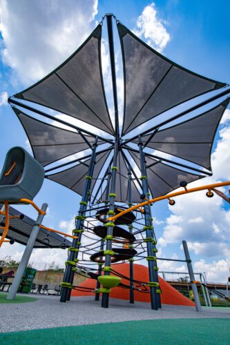 Climbing structure below large shade.