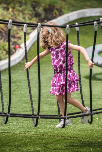 Girl crossing over net bridge