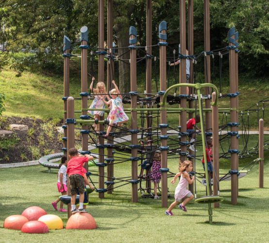 Kids playing on climbing playground equipment.
