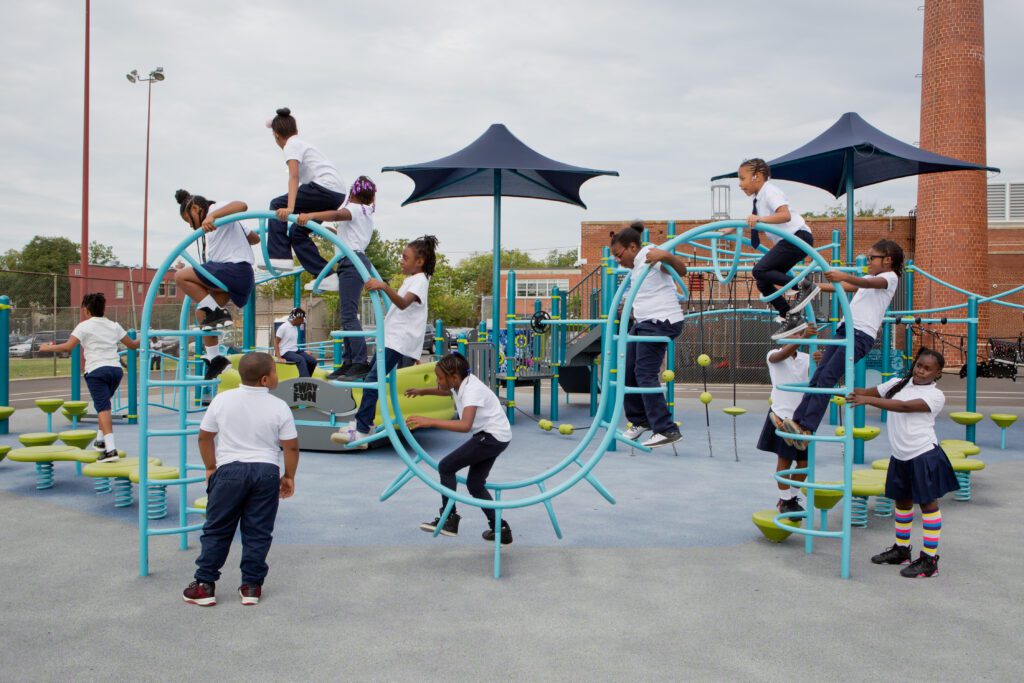 Kids playing on wavy climbing structure.