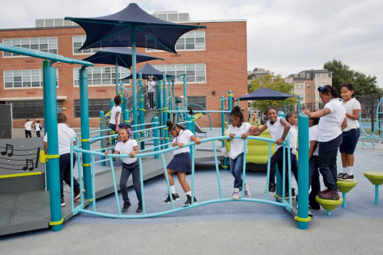 Kids crossing over playground bridge.