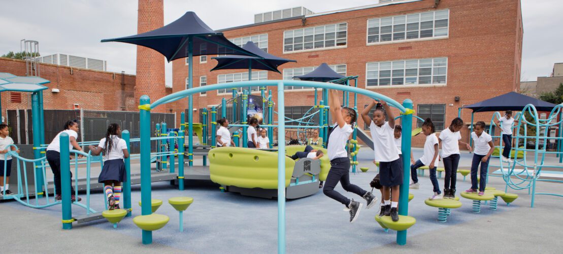 2 kids crossing over monkey bars.