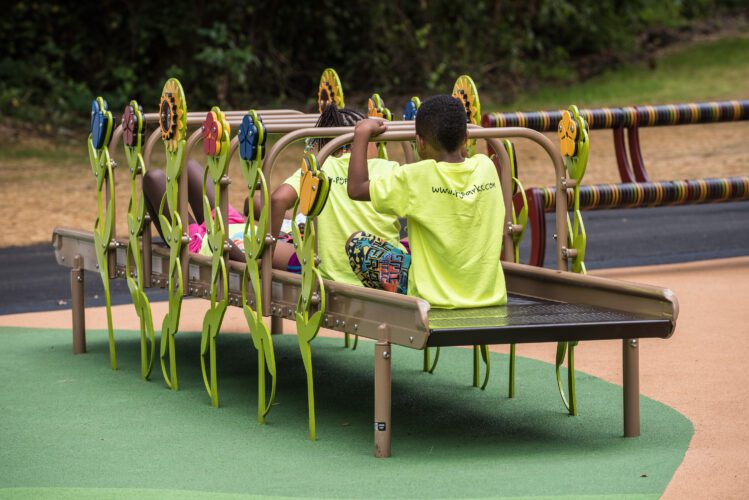 Kids going through flat, roller slide.