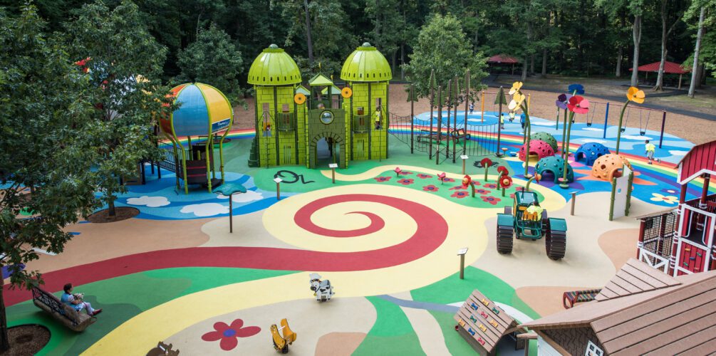 View of colorful surfacing in swirl pattern in center of playground.