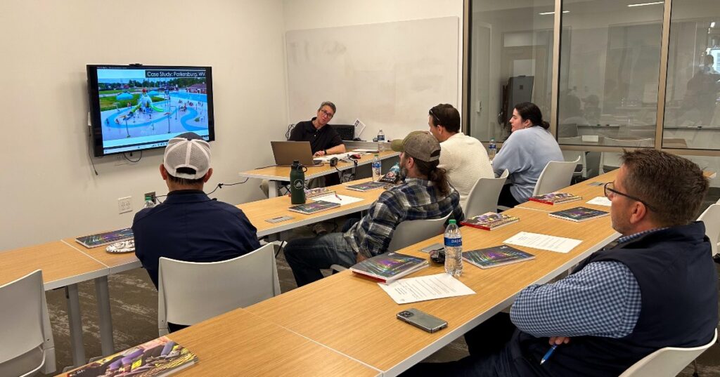 CEU class with employees sitting at tables looking at tv screen.