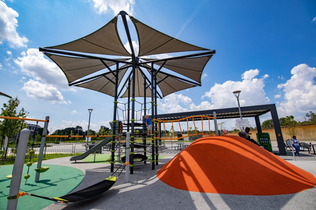 Skyways shade structure with 7 panels over playground equipment.