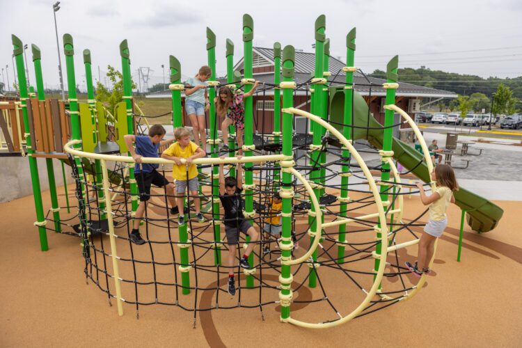 View of large playground equipment with netting in foreground.