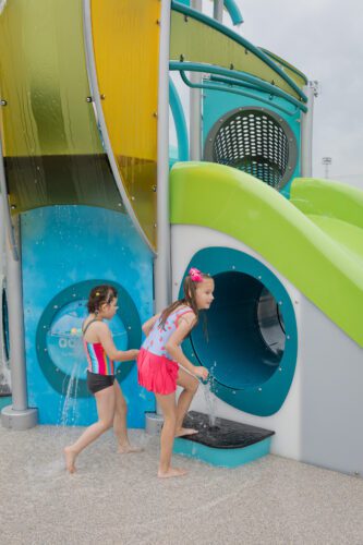 Two kids going through tunnels of playground structure.
