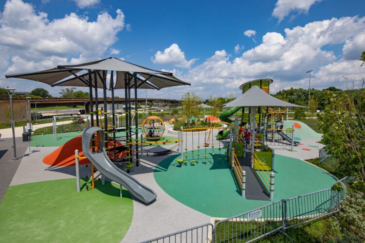 Overview of the Fields at RFK playground in Washington, DC, featuring custom LSI PlayBooster® tower, Netplex® structure, freestanding play components, and vibrant Poured-in-Place surfacing by Surface America, installed by Sparks at Play.