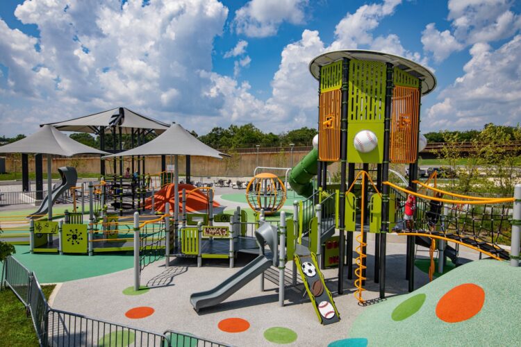 Overview of the Fields at RFK playground in Washington, DC, featuring custom LSI PlayBooster® tower, Netplex® structure, freestanding play components, and vibrant Poured-in-Place surfacing by Surface America, installed by Sparks at Play.