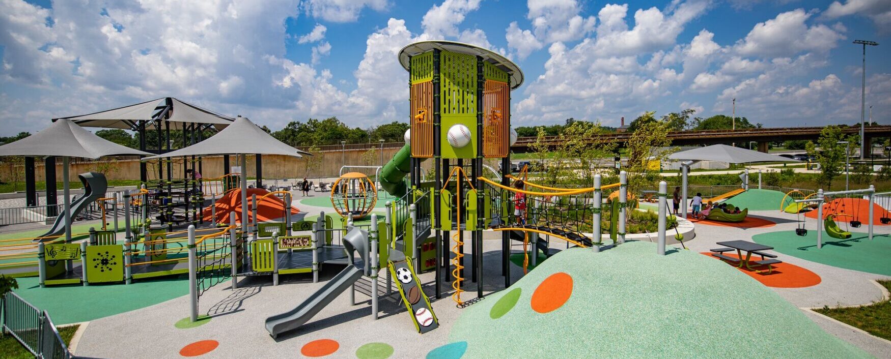 Overview of the Fields at RFK playground in Washington, DC, featuring custom LSI PlayBooster® tower, Netplex® structure, freestanding play components, and vibrant Poured-in-Place surfacing by Surface America, installed by Sparks at Play.