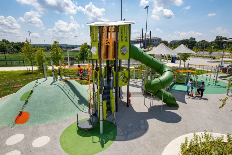 Overview of the Fields at RFK playground in Washington, DC, featuring custom LSI PlayBooster® tower, Netplex® structure, freestanding play components, and vibrant Poured-in-Place surfacing by Surface America, installed by Sparks at Play.