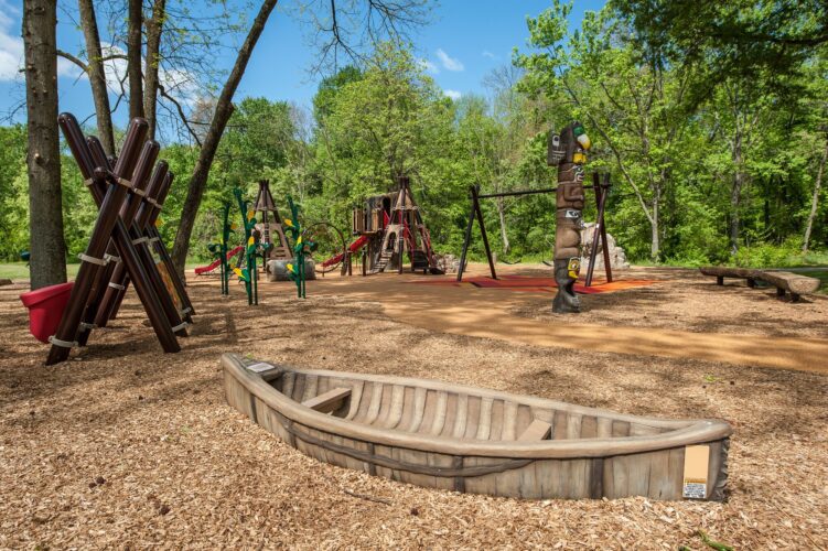 Custom Algonquian canoe play structure at the Indian Creek Playground in Berwyn Heights, MD, installed by Sparks at Play using LSI equipment.