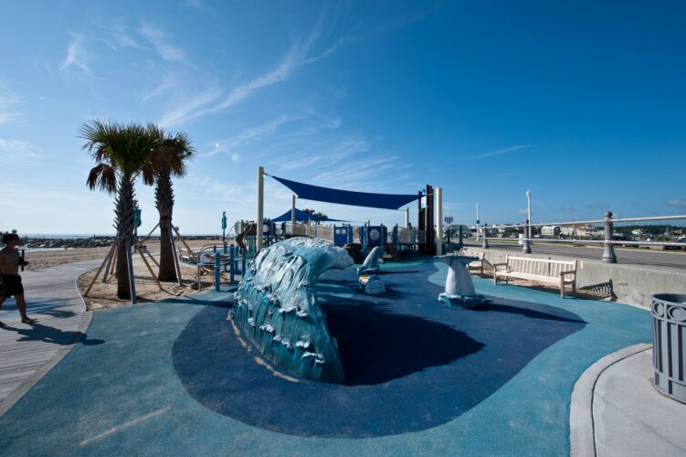 Ocean-themed play addition at JT's Grommet Island Beach Park Playground for EveryBODY in Virginia Beach, VA, featuring water-inspired design elements, installed by Sparks at Play using LSI equipment.