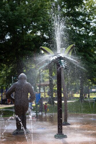 Norton Wood Booger GFRC statue in the distance with a ground jet water feature in the foreground at the City of Norton splash pad in Norton, Virginia, installed by Sparks at Play using Aquatix equipment.