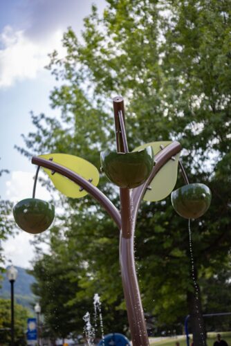 BucketTrio with acrylic water feature at the City of Norton splash pad in Norton, Virginia, providing tipping bucket sensory water play for children, installed by Sparks at Play using Aquatix equipment.