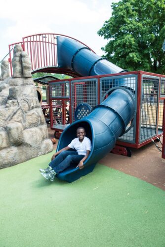 Child going down slide at Turkey Thicket Recreation Center playground Washington DC Landscape Structures