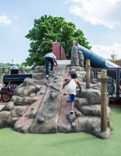 Kids climbing custom GFRC mountain at Turkey Thicket Recreation Center playground Washington DC Landscape Structures