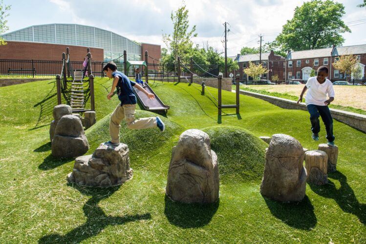 Kids playing on custom glass fiber reinforced concrete GFRC rocks at Turkey Thicket Recreation Center playground Washington DC