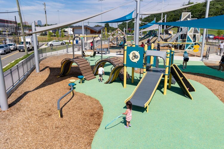 Overview of the Jennie Dean Park playground in Arlington, VA, featuring Alpha Link® Towers, age-specific play zones, hillside slides, and SkyWays® shade structures, installed by Sparks at Play using LSI equipment.