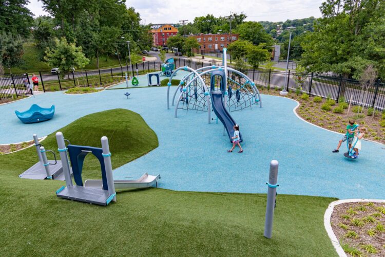 Elevated overview of the Ferebee-Hope Recreation Center playground in Washington, DC, featuring the Evos® 4-Arch play structure, hillside climbers, and separate play zones for ages 2–5 and 5–12.