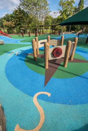 Overview of the Poured-in-Place surfacing with custom compass design at the Palisades Recreation Center playground in Washington, DC, installed by Sparks at Play using Surface America surfacing.