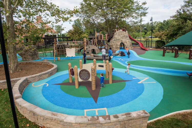 Overview of the Poured-in-Place surfacing with custom compass design at the Palisades Recreation Center playground in Washington, DC, installed by Sparks at Play using Surface America surfacing.