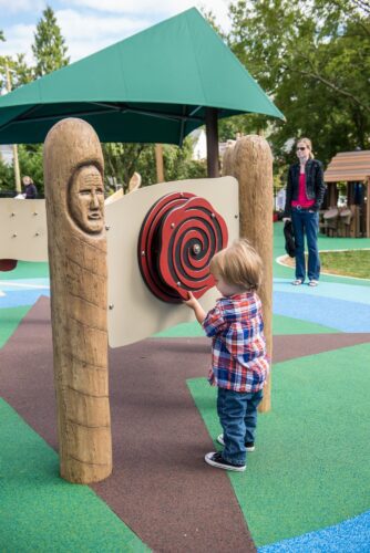 A child playing with a sensory panel at the Palisades Recreation Center playground in Washington, DC, installed by Sparks at Play using LSI equipment.