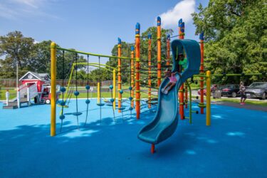 38th Ave Neighborhood Park orange Netplex climbing structure with Rush slide and colorful pour-in-place surfacing in Hyattsville MD