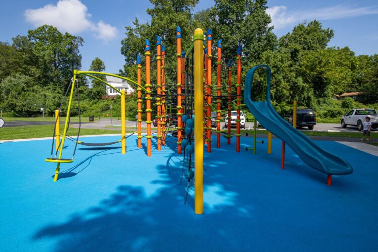 38th Ave Neighborhood Park orange Netplex climbing structure with Rush slide and colorful pour-in-place surfacing in Hyattsville MD