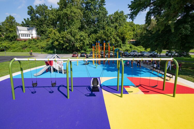38th Ave Neighborhood Park inclusive Friendship Swing on green arch swing frame with blue pour-in-place surfacing in Hyattsville MD