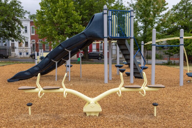 Close-up of Landscape Structures 4-seat seesaw at Franklin Square Elementary playground Baltimore MD