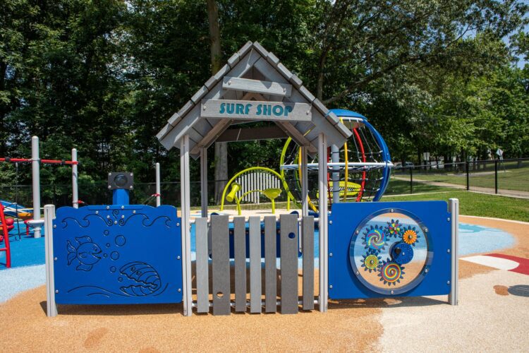 Surf Shop freestanding play structure with sensory panels for toddlers at beach-themed playground J. Franklyn Bourne Park