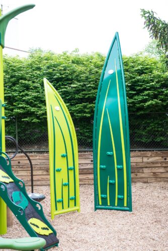 Custom grass-themed play structure with giant blade of grass climbers at the Prince George's County Childcare playground in Upper Marlboro, MD, installed by Sparks at Play using LSI equipment.