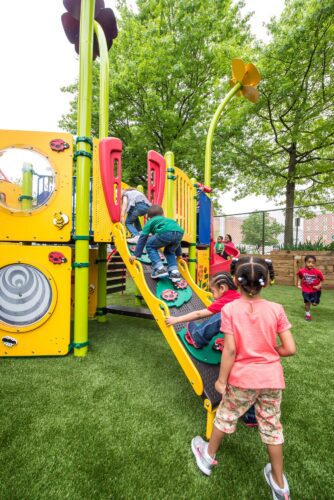 Children climbing up a bridge at the Prince George's County Childcare playground in Upper Marlboro, MD, installed by Sparks at Play using LSI equipment.
