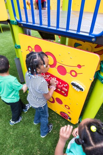 Interactive garden-themed learning panels featuring ladybugs, bumblebees, ants, and flowers at the Prince George's County Childcare playground in Upper Marlboro, MD, installed by Sparks at Play using LSI equipment.