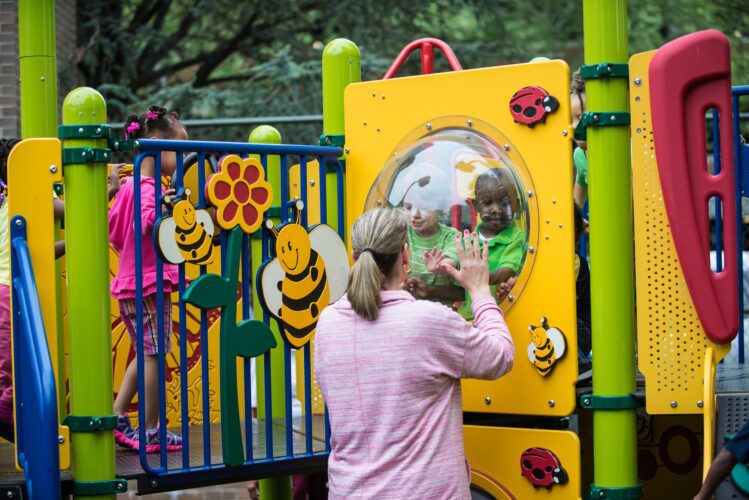 Interactive garden-themed learning panels featuring ladybugs, bumblebees, ants, and flowers at the Prince George's County Childcare playground in Upper Marlboro, MD, installed by Sparks at Play using LSI equipment.