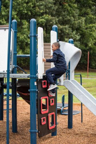Kid climbing up Landscape Structures Smart Play Venti at Princeton Elementary School playground Suitland MD