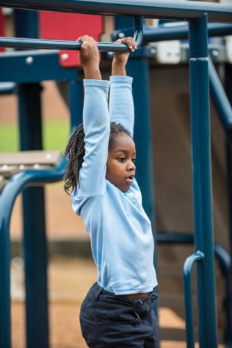 Kid climbing across Landscape Structures Smart Play Venti at Princeton Elementary School playground Suitland MD