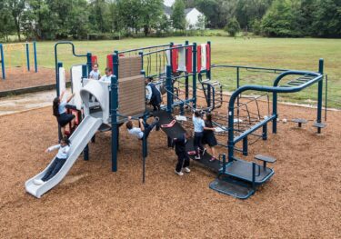 Overview of kids playing on Landscape Structures Smart Play Venti at Princeton Elementary School playground Suitland MD