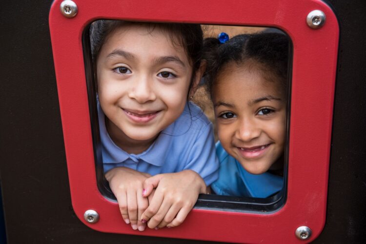 Kids peeking through opening on Landscape Structures Smart Play Venti at Princeton Elementary School playground Suitland MD