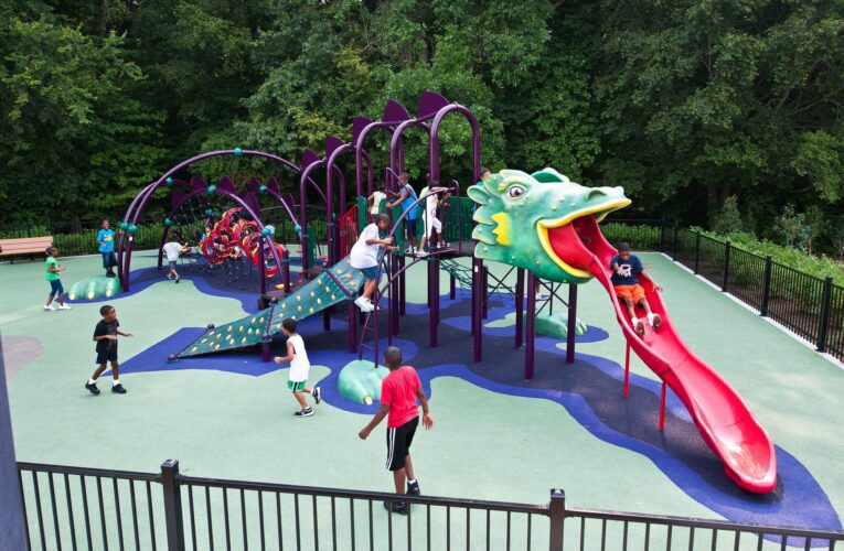 Full overview of the custom medieval-themed playground at South Bowie Community Center in Bowie, MD, featuring a giant Landscape Structures dragon play structure with climbing walls, a custom castle, and GFRC dragon eggs.