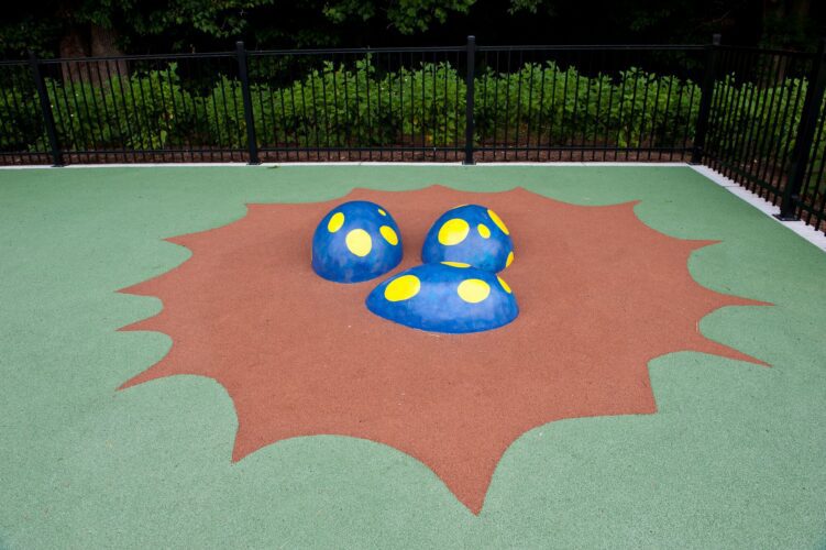 Custom GFRC dragon eggs nestled in a pour-in-place nest at the base of the medieval dragon playground at South Bowie Community Center in Bowie, MD.