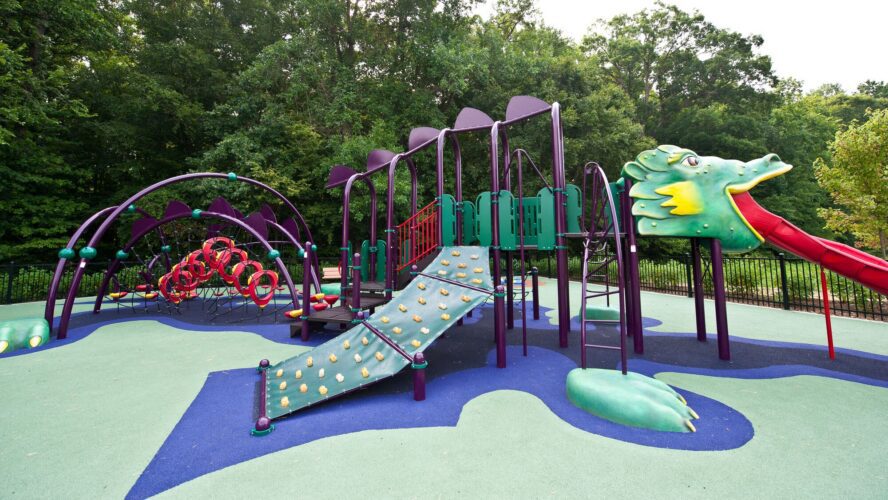 Full overview of the custom medieval-themed playground at South Bowie Community Center in Bowie, MD, featuring a giant Landscape Structures dragon play structure with climbing walls, a custom castle, and GFRC dragon eggs.