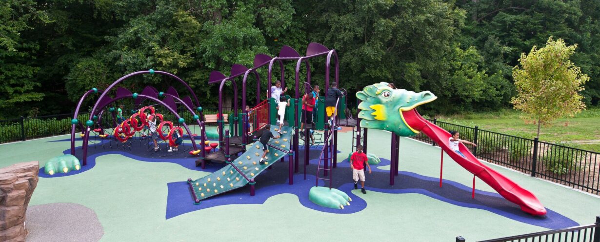 Full overview of the custom medieval-themed playground at South Bowie Community Center in Bowie, MD, featuring a giant Landscape Structures dragon play structure with climbing walls, a custom castle, and GFRC dragon eggs.